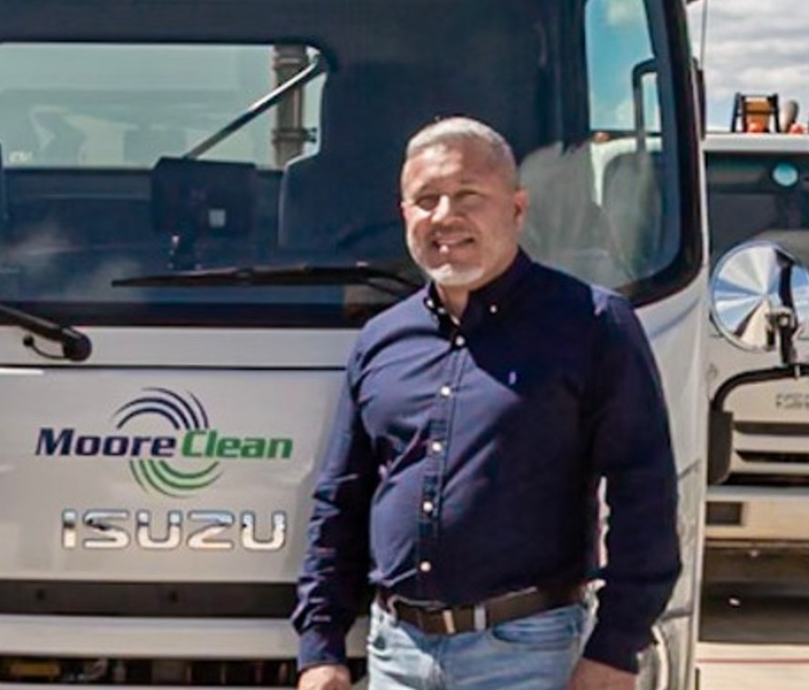 Closeup of Jose Moore standing in front of company truck